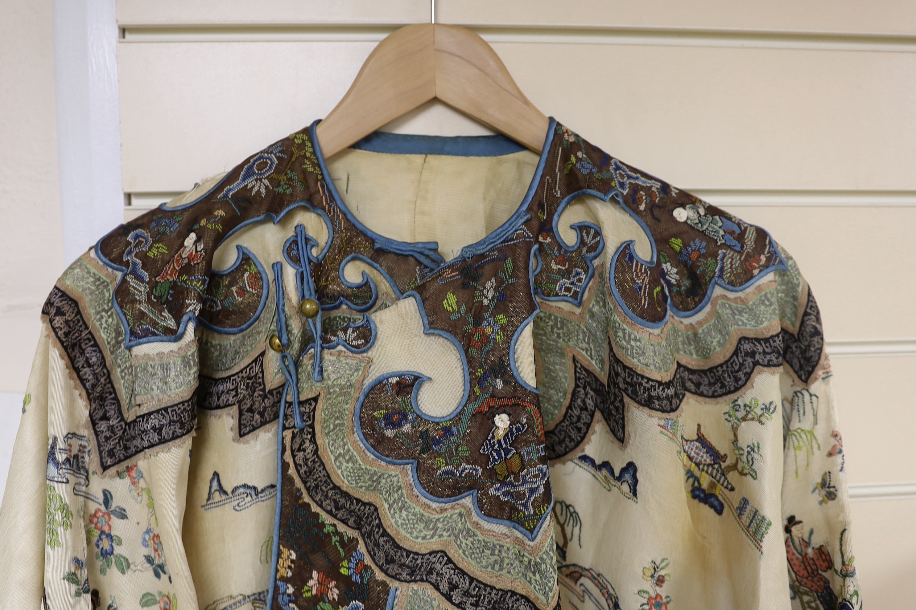 A late 19th/early 20th century Chinese gauze summer robe embroidered with flowers, figures and pagodas, 85cm high
